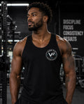 Man wearing black Vida Fit Tank Top in gym with Discipline Focus Consistency Results wall