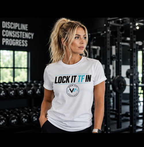 Woman wearing white Lock It TF In Tee by Vida Fit in gym setting