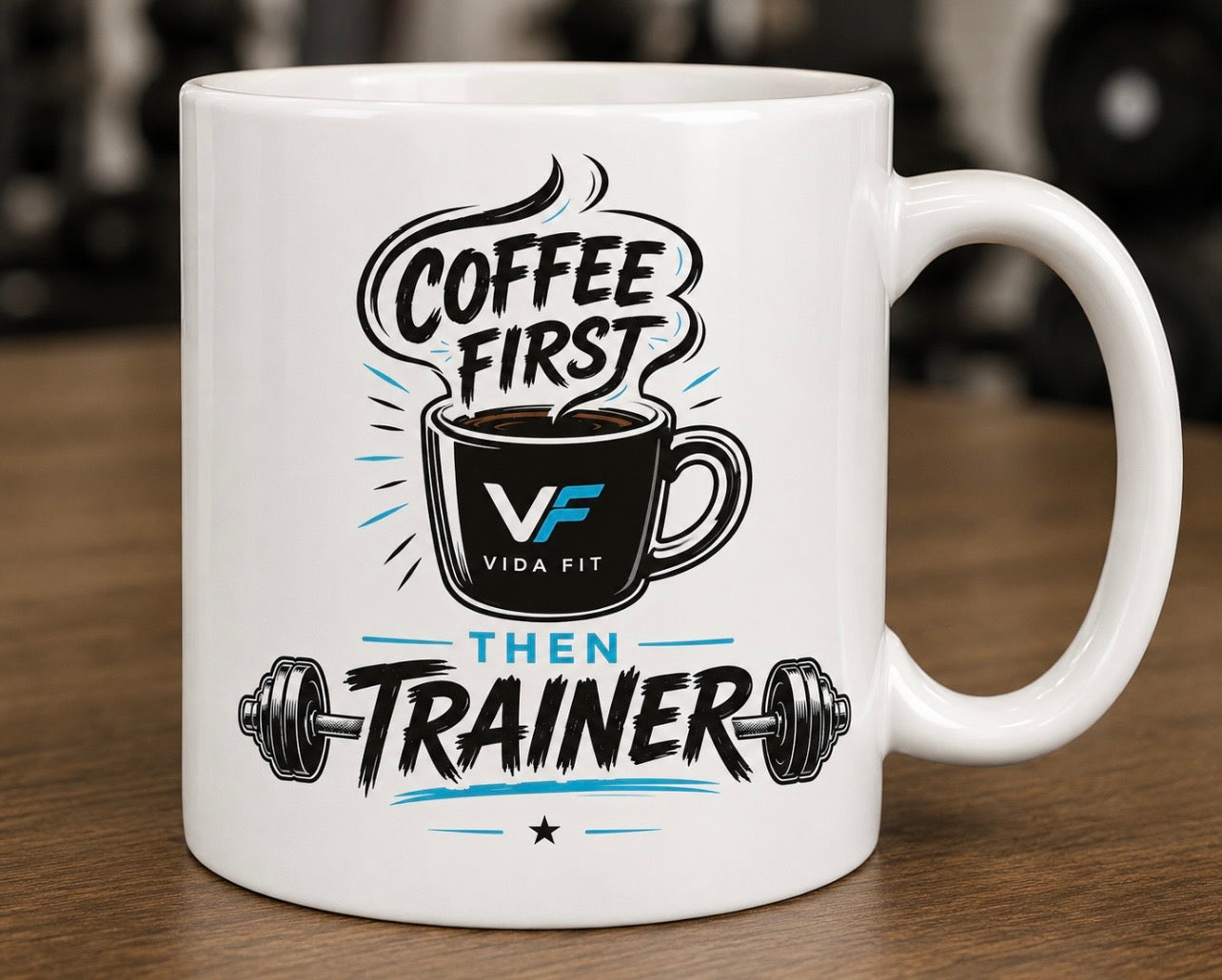 Coffee First Then Trainer white ceramic mug with Vida Fit logo on wooden surface