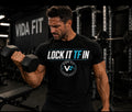 Man curling dumbbell wearing black Lock It TF In Tee by Vida Fit